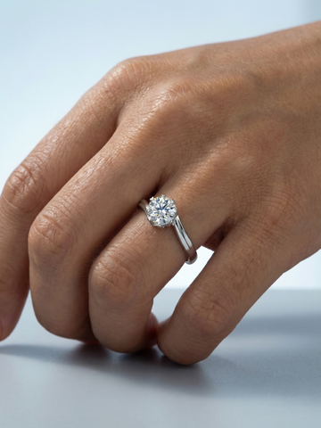 WryWry Moissanite Swoop Ring featuring a sleek silver band with sparkling moissanite stones arranged in a swooping design.