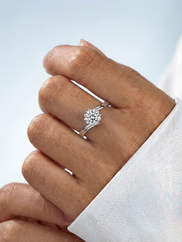 WryWry Moissanite Swoop Ring featuring a sparkling, curved band with a central moissanite gemstone on a silver setting.